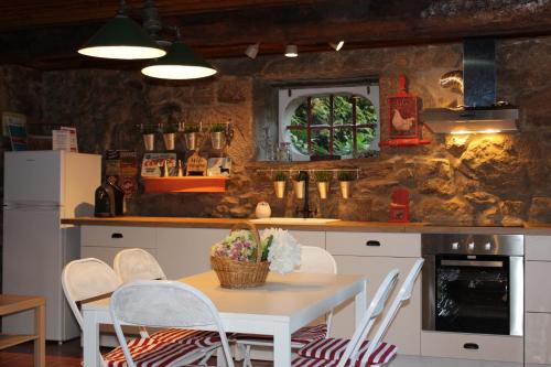 a kitchen with a table and chairs in a room at Quinta da Maínha - Charming Houses - Escape to Nature in Braga
