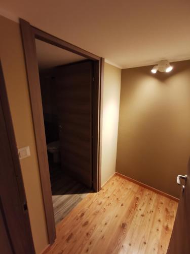 an empty room with an open door and wood floors at Casa Curnet in Balme