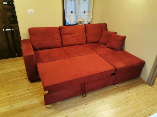 a red couch sitting in a living room at Casa Curnet in Balme