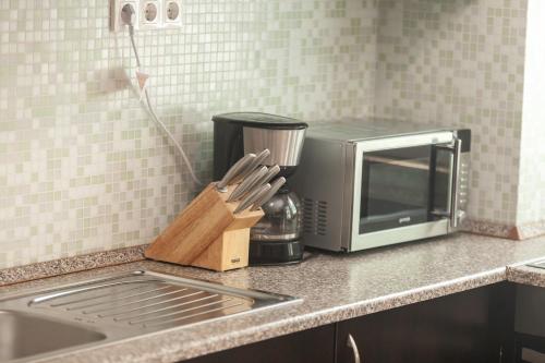 a kitchen counter with a microwave and a knife block at Bella Villa in Siófok