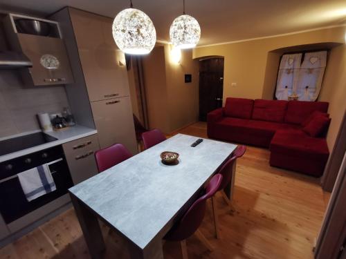 a kitchen and living room with a table and a red couch at casa curnet in Balme