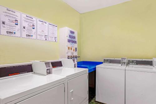 a laundry room with two machines and a blue bench at La Quinta by Wyndham Miami Lakes in Miami Lakes