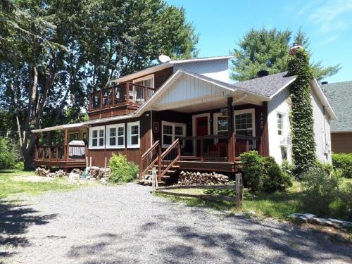a large house with a porch and a balcony at Escale du loup in Saint-Paulin