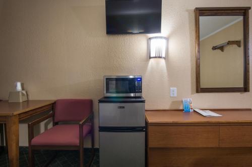 a microwave sitting on top of a refrigerator next to a desk at Red River Inn Silt - Rifle in Silt