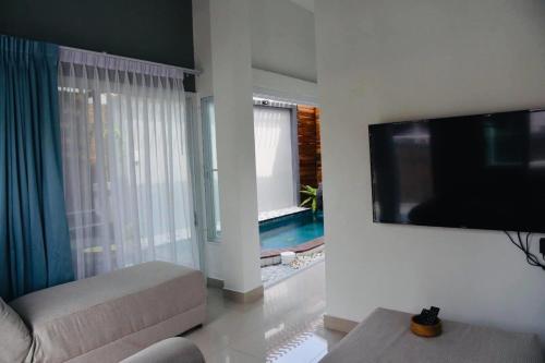een woonkamer met een flatscreen-tv en een bank bij Origin hua hin poolvilla in Hua Hin