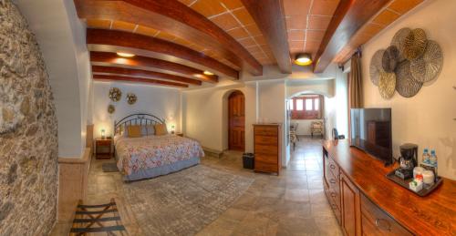 a bedroom with a bed and a tv in a room at Hotel Santa Paula in Taxco de Alarcón