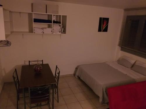 a bedroom with a bed and a table and a table and chairs at Studio à fort de France in Fort-de-France