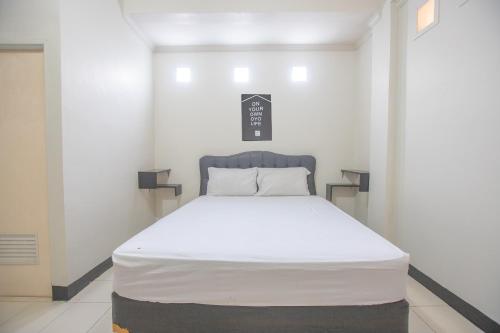 a bed in a white room with a white mattress at BTX 31 Residence Bintaro in Peladen