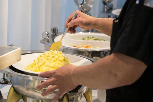 a man is preparing food in a kitchen at Ambience Hotel Taipei in Taipei