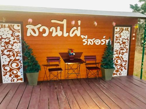 a patio with a table and chairs on a deck at สวนไผ่รีสอร์ท in Ban Na