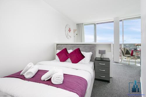 a bedroom with a large bed with purple pillows at City View Apartments Rotunda in Birmingham