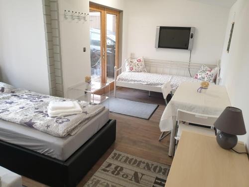 a room with two beds and a living room with a tv at MyRooms in Schönfließ