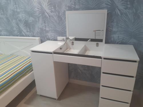 einen weißen Schreibtisch mit einem Spiegel im Schlafzimmer in der Unterkunft Apartment near stadio Metalist Kharkiv in Kharkov
