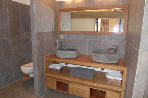 a bathroom with two sinks and a toilet at Le Domaine des Doucins & Spa, Gîte 4 étoiles, 10 minutes de Jonzac piscine et spa in Fontaines-dʼOzillac