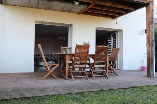 uma mesa de madeira e cadeiras num pátio em Commealamaison em Saint-Louis