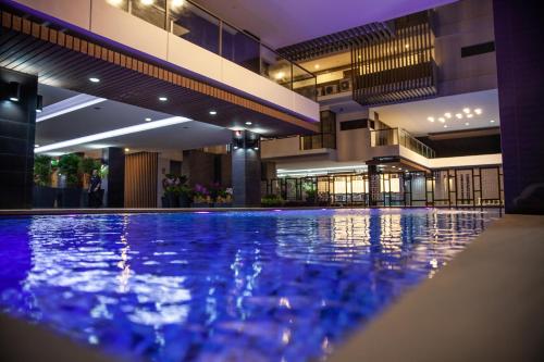 a large swimming pool in a hotel lobby at Mae Phim Holiday Escape Completely in Mae Pim