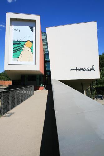 a sign on the side of a building with a tree at Gîte Mozaïk in Louvain-la-Neuve