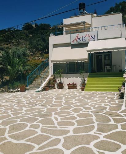 a building with a stone patio in front of it at Aaron Studios Apartments in Agia Fotia