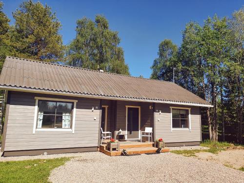 una pequeña casa con dos sillas delante en Lucky Ranch cabin 3 en Pyhätunturi