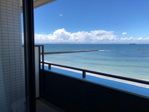 a view of the ocean from a balcony at Support Inn Minami-Chita Annex Hamachaya in Minamichita