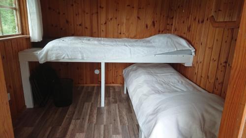 a room with two bunk beds in a cabin at Liten enklare klimatsmart stuga i Roslagen in Östhammar