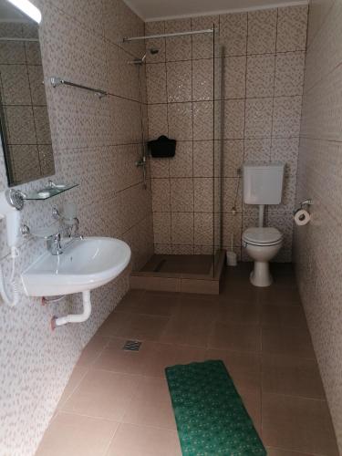 a bathroom with a sink and a shower and a toilet at Hotel Coralis 2 in Eforie Nord