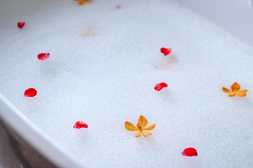 a white tray with red and orange flowers on it at The Shore At Katathani - Adult Only - SHA Extra Plus in Kata Beach