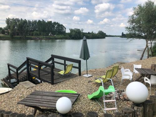 a table and chairs and an umbrella next to a river at Vila Sunce Morovic in Morović