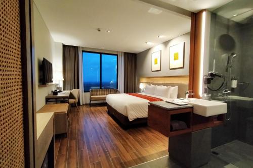 a hotel room with a bed and a sink at Kokoon Hotel Banyuwangi in Banyuwangi