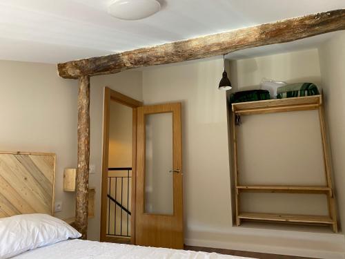 a bedroom with a bed and a wooden beam at Casa del Portón - Housevanlive in Casas Altas
