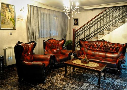 two leather chairs and a coffee table in a living room at Hotel Evropa in Podgorica