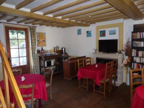 une salle à manger avec deux tables et une cheminée dans l'établissement Chambres et Tables d'hôtes à l'Auberge Touristique, à Meuvaines