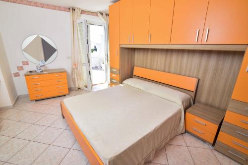 a bedroom with a bed with orange cabinets and a mirror at SOLEMAREPONZA Casa la Randa in Ponza