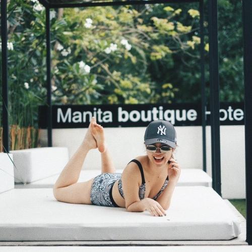 a woman laying on a mattress talking on a cell phone at Manita Boutique Hotel in Pattaya South
