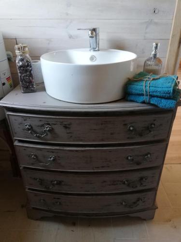 a bathroom sink sitting on top of a wooden dresser at Domek Gościnny in Darłowo