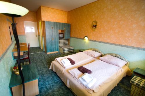 Un pat sau paturi într-o cameră la Piknik Wellness Hotel