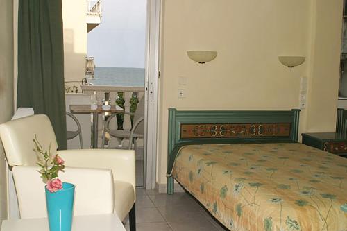 um quarto com uma cama, uma mesa e cadeiras em Villa Niki em Olympiakí Aktí