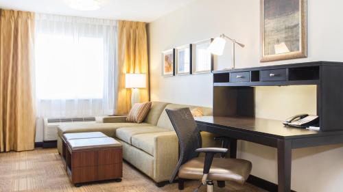 a living room with a couch and a desk in a hotel room at Staybridge Suites West Edmonton by IHG in Edmonton
