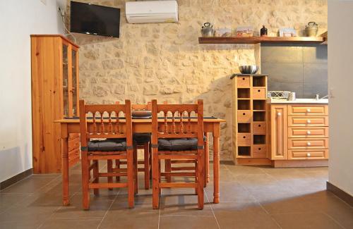 cocina con mesa de madera y sillas en Casa Manolita, en Calaceite