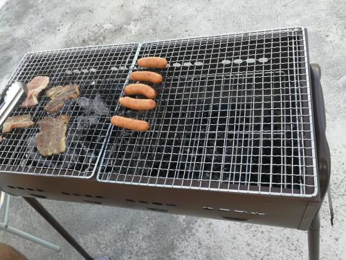 a grill with four hot dogs on it at NahaCentaral_10Beds7roomsHouse_190sqm_FreeParking in Naha