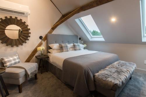 a bedroom with a bed and a mirror and a chair at Mountain Meadows Lodge in Killington
