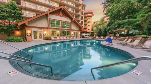 a swimming pool with chairs and a building at Holiday Inn Club Vacations Smoky Mountain Resort in Gatlinburg