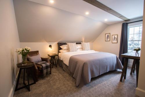 a bedroom with a bed and a chair and a window at Mountain Meadows Lodge in Killington