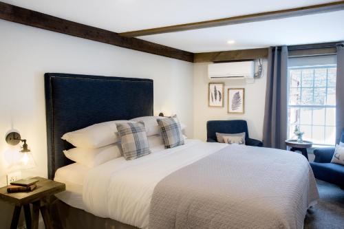 a bedroom with a large white bed with pillows at Mountain Meadows Lodge in Killington
