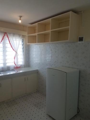 a kitchen with white cabinets and a sink and a window at Ocean View Nyali Boutique Hotel in Nyali