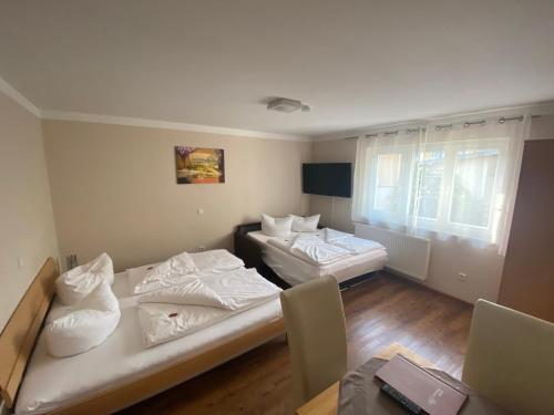 2 camas en una habitación con mesa y sillas en Hotel Alex en Stammham