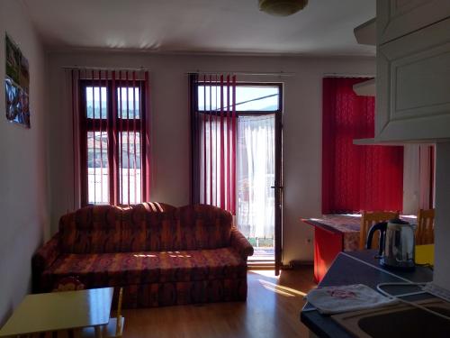 a living room with a couch and two windows at Guest House - Batak in Batak