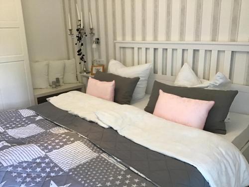 a bedroom with two beds with pink and grey pillows at Villa Florentine in Bad Liebenstein
