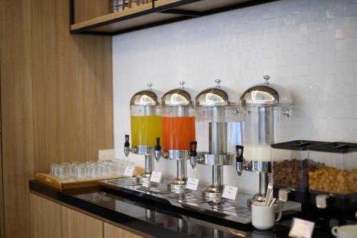 a kitchen counter with a bunch of different colored drinks at Monte Maesot hotel in Mae Sot