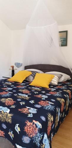 sypialnia z łóżkiem z żółtymi poduszkami w obiekcie Apartment Monica w mieście Senj
